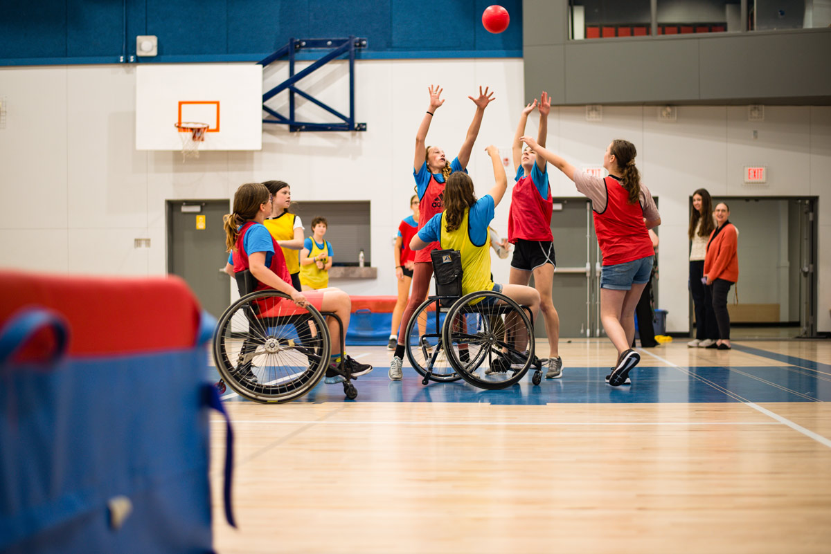 Female middle-school Students play baskteball in wheelchairs